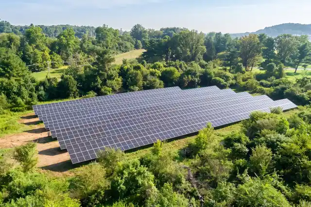 Ground-mounted solar array at St. Thomas Church in Fort Washington, surrounded by trees
